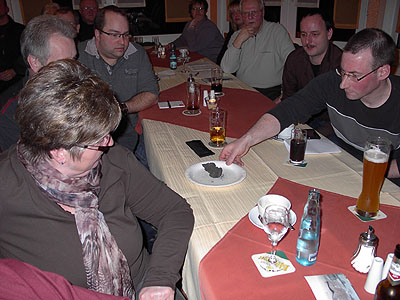 6 Personen sitzend an einem Tisch, im Vordergrund sitzt eine Frau